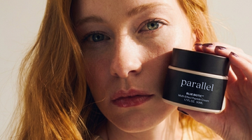 woman holding jar of blue biotic peptide cream